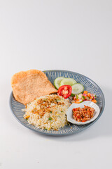 A plate of food with rice, vegetables, and a dipping sauce. The plate is blue and white