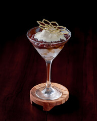A dessert in a glass with a leaf on top.
