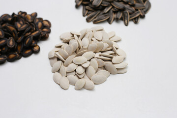 Roasted pumpkin seeds on white background.