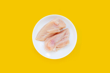 Uncooked raw chicken  breast fillets on yellow background.