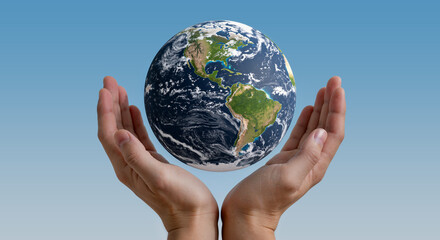 Hands holding the globe against a blue background  