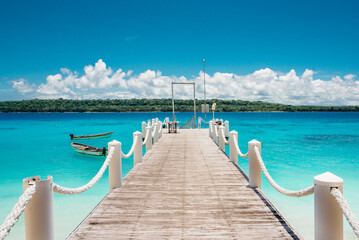 Stunning wooden pier extending into clear turquoise waters on Bokissa Island in Vanuatu, surrounded by lush greenery