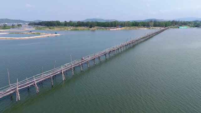Wooden Ong Cop bridge extends across blue-green waters, connecting shores in scenic Phu Yen, Vietnam