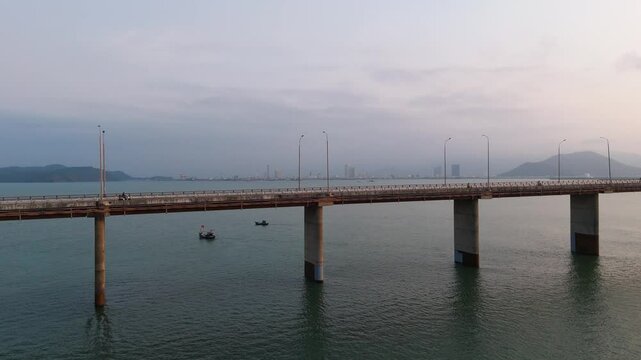 Drone shot of concrete pillars of Thi Tai bridge stretching across calm waters in Binh Dinh, Vietnam