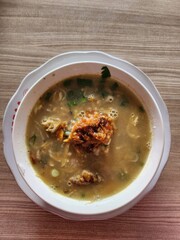 Spicy, savory noodle soup with fried shallots and meat.