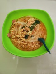 Flavorful instant noodles in a vibrant green bowl.