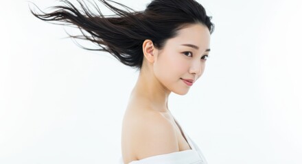 Fototapeta premium Young Asian woman with flowing hair on white background