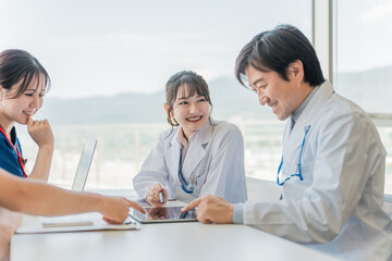 医局でカンファレンス・打ち合わせ・ミーティングする男女の看護師・技師・作業療法士・理学療法士・医師
