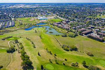 Golf course with a pond and a few houses in the background