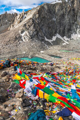 Tibetan praying flags at the Gauri Kund mountain lake during the ritual kora yatra around Kailash,...