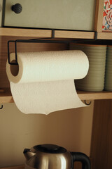 Kitchen towel roll hanging in a bright domestic kitchen setting