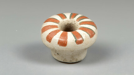 White and red striped ceramic candlestick holder on gray background, ideal for home decor or still life photography