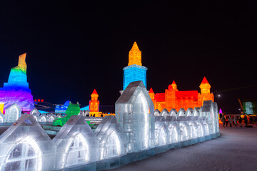 January 1, 2022, HARBIN, CHINA. Horizontal image of spectacular illuminated white ice sculptures in Harbin, China. Night picture with copy space for text