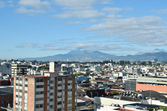 Ciudad capital de Guatemala, al fondo el volc&aacute;n de Agua, cubierto de nubes.