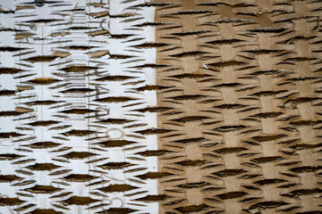 Abstract pattern of cut and layered cardboard with contrasting light and brown tones