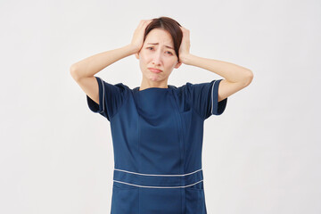 女性　美容看護師　頭を抱える　白背景