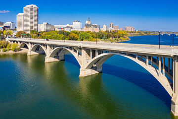 Naklejka premium Bridge spans a river with a city in the background