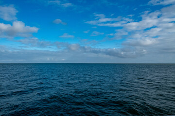 Obraz premium A beautifully serene seascape depicting calm, clear waters alongside a vast blue sky, ideal for tranquil imagery