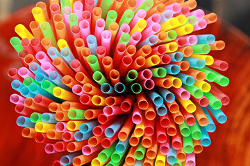 Colorful plastic straws for drinking water in the background