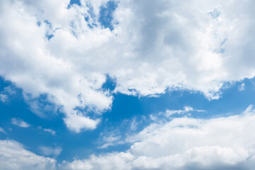 Clear blue sky with a few clouds. The sky is very bright and the clouds are scattered throughout. 