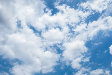 Clear blue sky with a few clouds. The sky is very bright and the clouds are scattered throughout. 