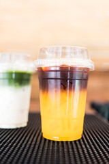 Iced Americano orange and iced matcha latte green tea. Close up