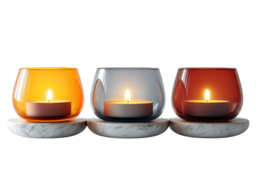 Three glowing glass candle holders on marble bases amber grey and red hues casting warm light creating a serene and inviting ambiance in a on transparent background