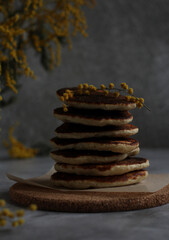 pancakes in rows in a close-up with mimosa on a gray background