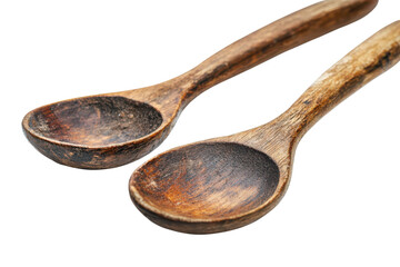 Two rustic aged wooden spoons rich brown tones showing signs of use and time isolated on black on...