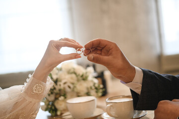 The bride and groom are holding wedding rings.