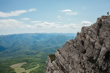 Male looking at landscape green forest from mountain top