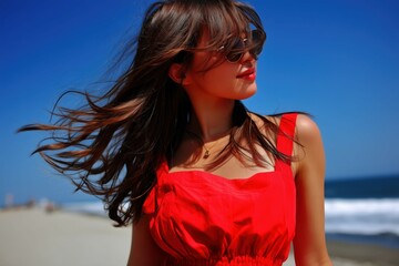 海を眺める赤いドレスの若い女性