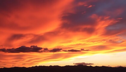 Obraz premium Epic sunset paints the sky with fiery hues over the mountain range silhouette