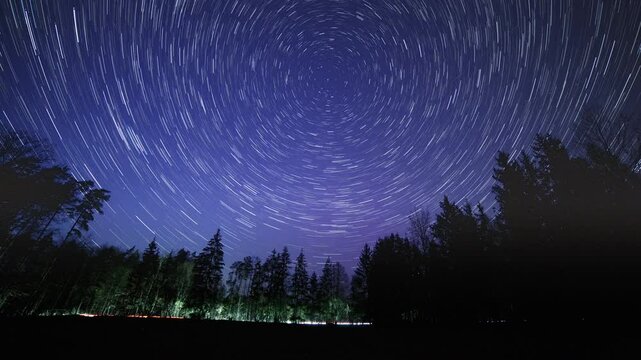 Night sky 4k time lapse with star trails over forest. Abstract time lapse with startrails.