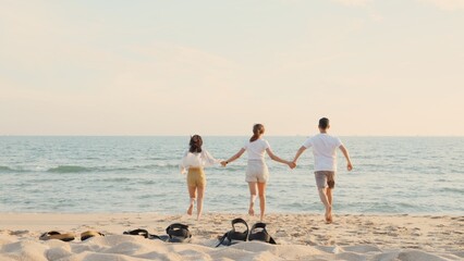 Happy friends holding hands running enjoy life funny and freedom on sand at beach together to sea in holiday vacation time at sunset, Young Asian group woman and man in summer travel, people lifestyle