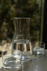 a glass container with water and two glasses