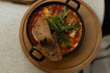 shakshuka in a frying pan with slices of bread, top view, breakfast