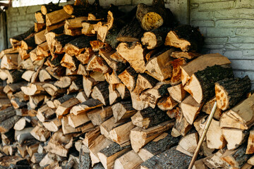 A neatly stacked pile of chopped firewood, ready for use. Ideal for outdoor lifestyle, home heating, camping, and rustic-themed designs.