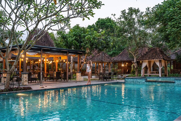 Tourist relaxing at luxurious resort pool in bali enjoying summer vacation