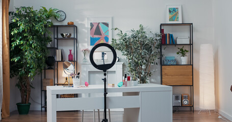 Woman with dark skin and long black dreadlocks walks into room prepared to record makeup videos for...