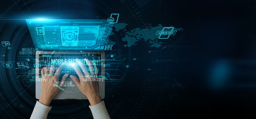 A man using a laptop with the Mobile Security on the keyboard is analyzing and developing various...
