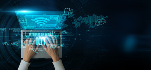 IoT.. A man using a laptop with the Internet of Things on the keyboard analyzes and develops...
