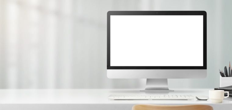 明るい光の差し込むオフィスのデスク上にある、大型のコンピューター