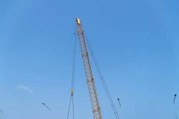 Industrial aerial view construction crane at building site under blue sky