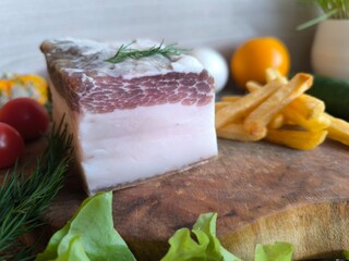 Delicious bacon from brisket on a wooden chopping board.