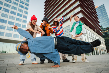 Dynamic group of talented dancers showcasing impressive break dance moves in urban environment with...