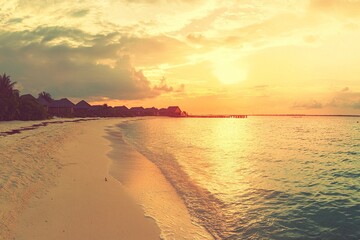 Fototapeta premium Beautiful sunset on the beach with sky and clouds. Stunning seascape background. Panoramic view of the sea, sand, and waves on a summer day. Vintage tone effect. Sunlight reflecting on the ocean water
