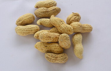 Whole unshelled peanuts on white background, perfect for food, nutrition, and healthy snack concepts in natural composition