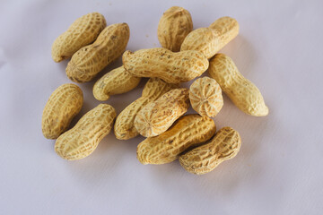 Whole unshelled peanuts on white background, perfect for food, nutrition, and healthy snack concepts in natural composition