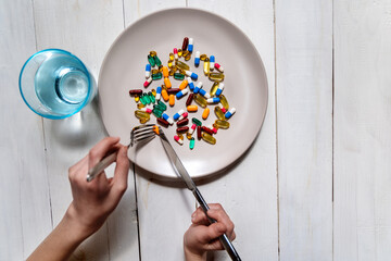 Pills and supplements served as meal concept. Assorted colorful capsules and tablets on a plate...